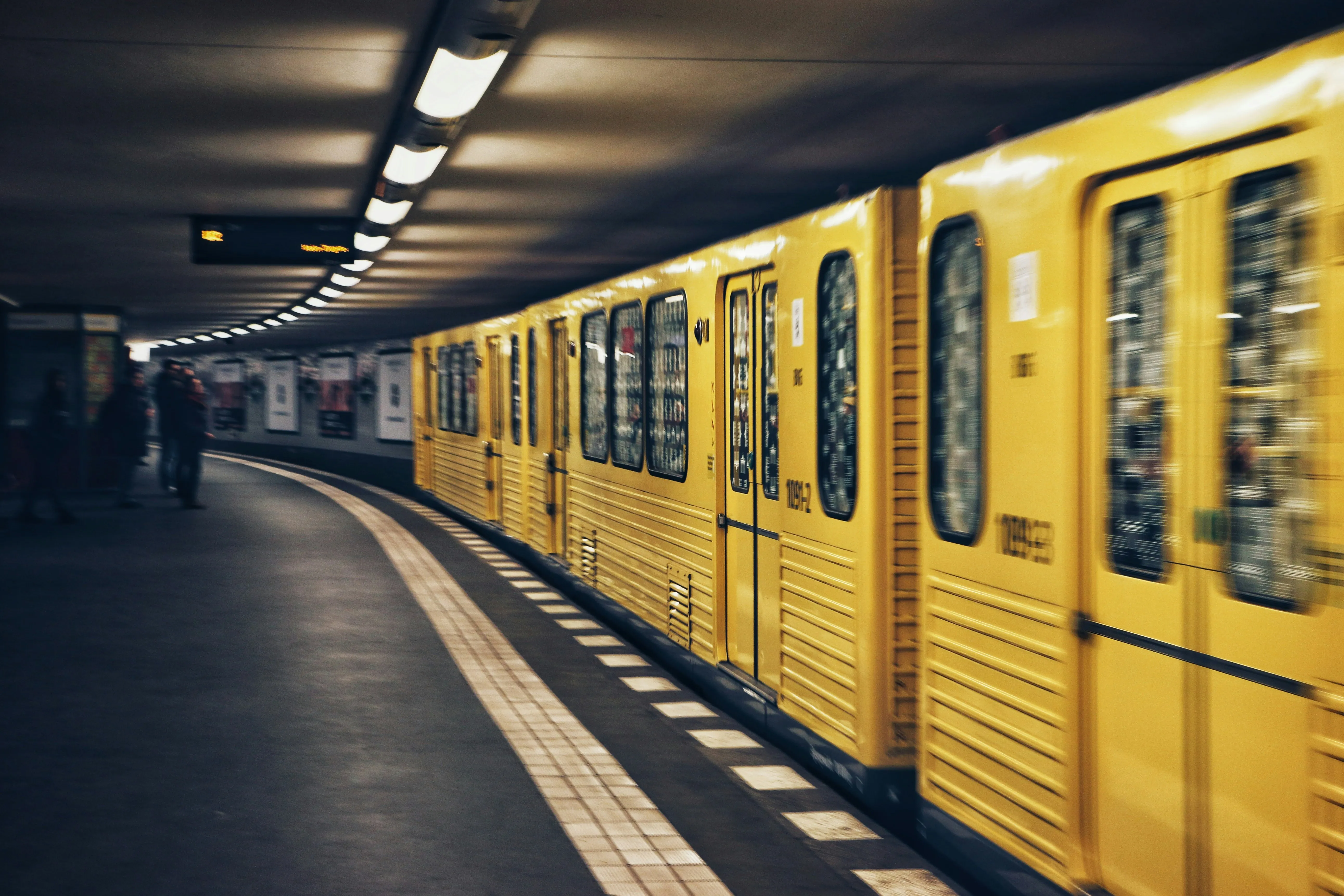 Yellow train arriving at a metro station
